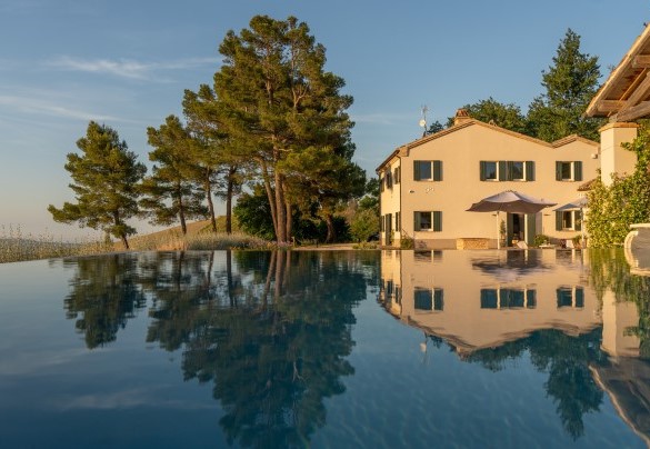 Suggestiva immagine della piscina a sfioro con rivestimento in telo PVC grigio scuro essenziale - Villa Dianella