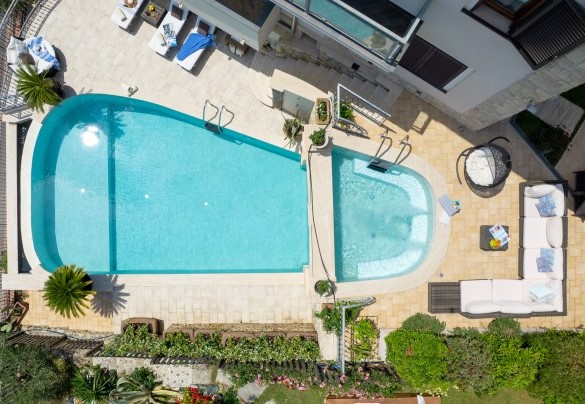 La piscina ha forma rettangolare con due lati stondati, con misure di 9 x 6 m nel punto più largo e 9 x 3 m nel lato più stretto e profondità variabile da un minimo di 1,70 m fino a 2,40 m – Villa Dolphin 10
