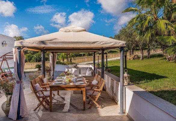 Gazebo attrezzato con divani, tavolo e sedie, con adiacente l’oliveto e il barbecue in pietra – Villa Donna Agaver