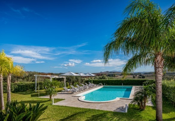 Scendendo una rampa di quattro scalini si raggiunge il solarium attrezzato con lettini e tavolini che circondano la piscina – Villa Donna Agaver