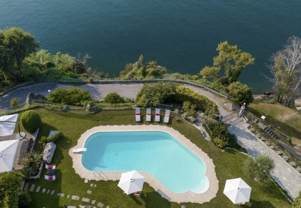 The irregularly shaped swimming pool is surrounded by a well-kept carpet of grass – Villa Eden
