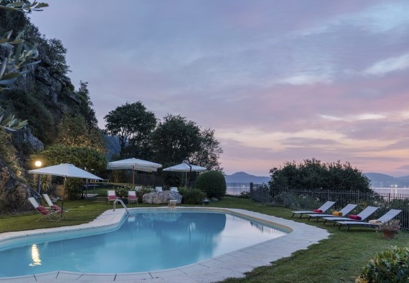 The irregularly shaped swimming pool is surrounded by a well-kept carpet of grass – Villa Eden