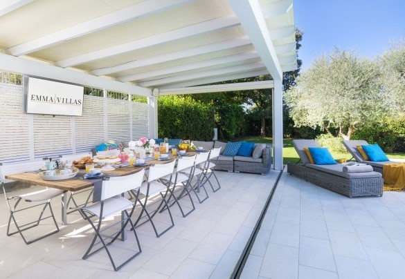 Il portico a bordo piscina con la zona living e pranzo esterna adiacente alla cucina e al bagno - Villa Edoardo