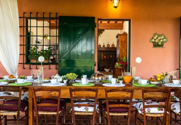 The porch shades the table prepared for outdoor breakfast – Villa Elisa 