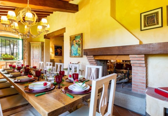 The living with table set and fireplace not in use– Villa Elisa 