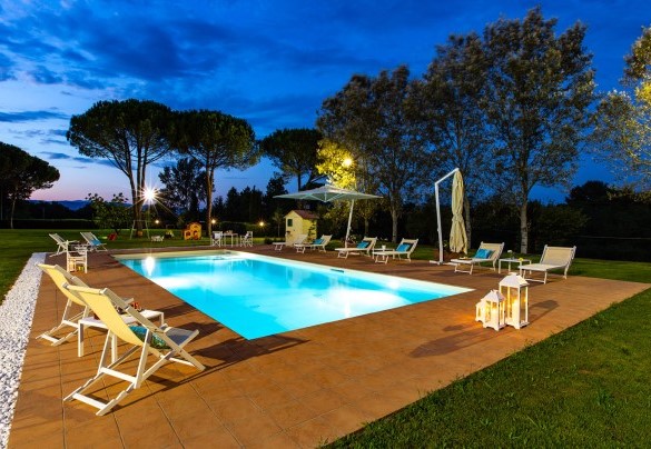 The sunset behind the hills and the pool which lights – Villa Elisa 