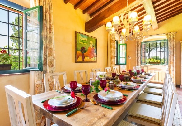 The living with table set and fireplace not in use– Villa Elisa