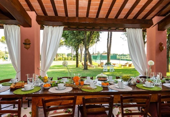 The porch shades the table prepared for outdoor breakfast – Villa Elisa 