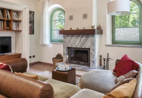 un ampio e luminoso soggiorno caratterizzato da un angolo bar, un’accogliente zona pranzo e una area relax/tv con camino ornamentale - Villa Elsa