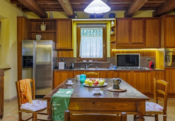 Spacious kitchen with fireplace and dining table - Villa Emilianna