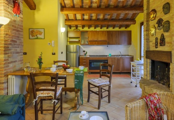 Kitchen with dining table and fireplace of the annex - Villa Emilianna