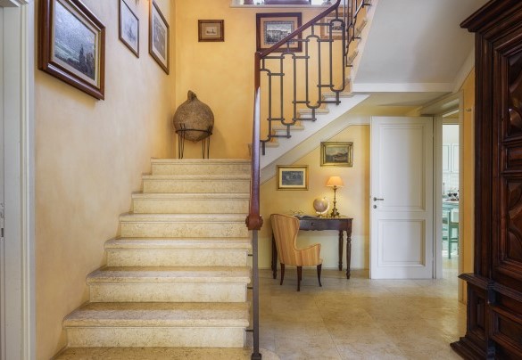 L’elegante scala in marmo con ringhiera in ferro battuto che conduce ai piani superiori – Villa Gaius