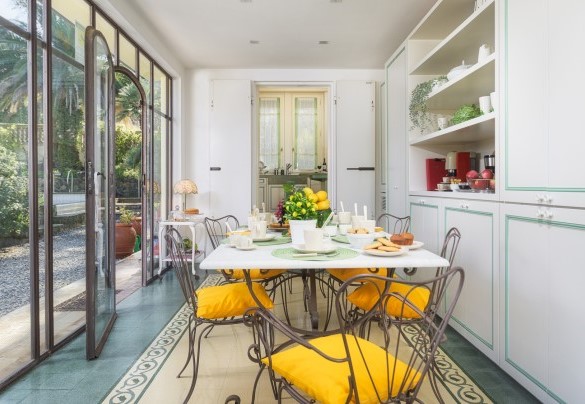 La bellissima veranda racchiusa da vetrate rifinite in ferro battuto e molto luminosa, dove è allestita la sala da pranzo con un elegante tavolo in marmo collegata con la cucina – Villa Gaius