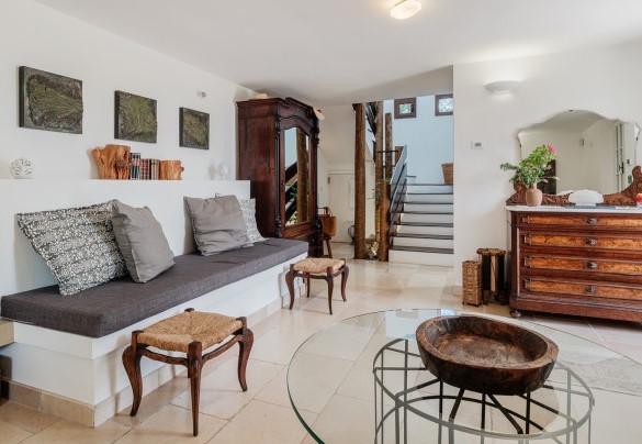 La living con divano in muratura collegata alla scala di accesso al piano superiore - Villa Giari