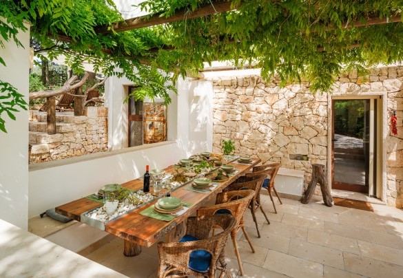 Il pergolato all'uscita della cucina ospita un tavolo con sedie per pranzi all'aperto - Villa Giari