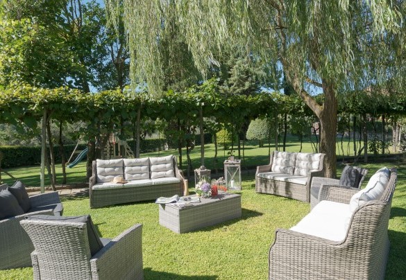 Outdoor living area with comfortable sofas and armchairs in the shade of ancient trees– Villa Ginestraio