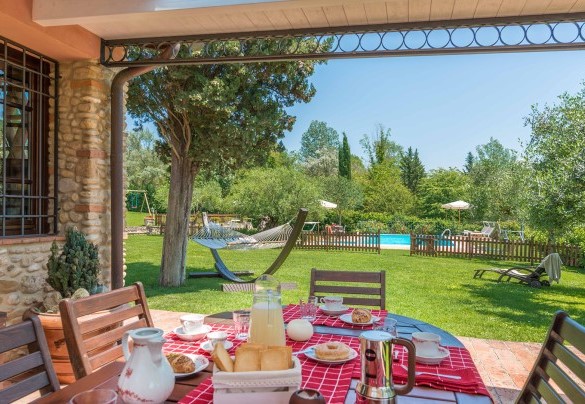 The porch shades the table prepared for outdoor breakfast – Villa Gino 
