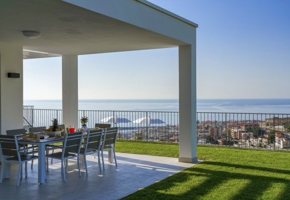 La bella vista sul mare e sulla città di Sanremo dalla terrazza coperta con il tavolo da pranzo nel secondo livello del giardino – Villa Gioia
