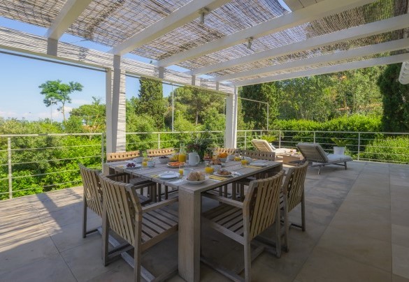 The dining area on the terrace has a staircase to access the pool area - Villa Giomoa