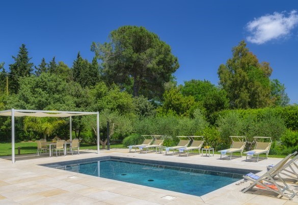 The swimming pool is located on a stoneware floor and around there are lougers for relax - Villa Giomoa
