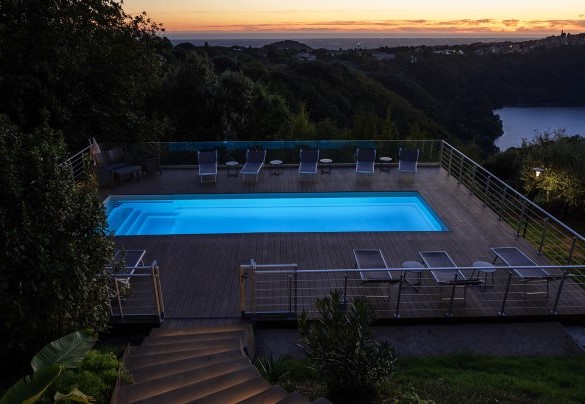 The pool suspended on a panoramic deck, enveloped in the warm light of the sunset – Villa Giulia