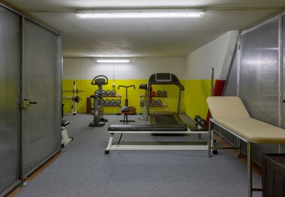 L’ampio garage, all'interno del quale c'è una zona fitness provvista di attrezzi per la palestra, un tapis roulant e una cyclette – Villa Guidi