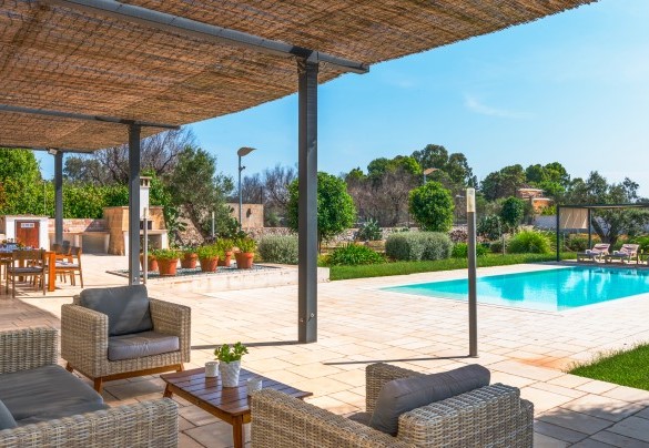 Il patio è separato dalla piscina e dal prato circostante da due gradini ed è adiacente alla zona dedicata al barbecue con forno a legna - I Chiani