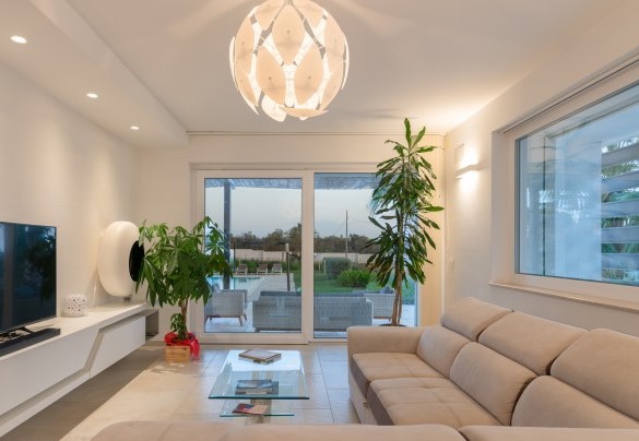 La grande porta vetrata che illumina il salotto, lo rende un’unica grande zona living con il patio esterno - Villa I Chiani
