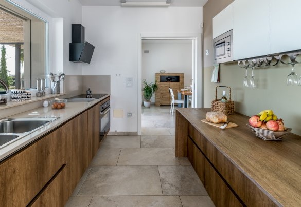 Dalla sala da pranzo si accede alla cucina a vista, completamente accessoriata e con ampi piani di lavoro - Villa I Chiani