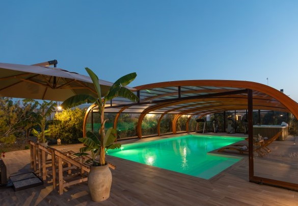 Area piscina esterna illuminata di sera – Villa I Mori