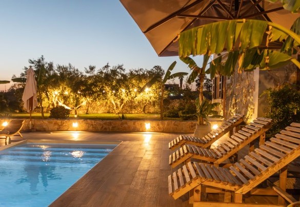 Area piscina esterna illuminata di sera – Villa I Mori
