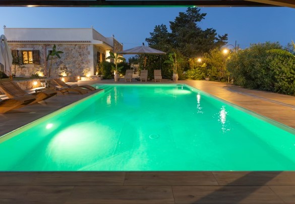 Suggestiva piscina esterna illuminata di sera – Villa I Mori