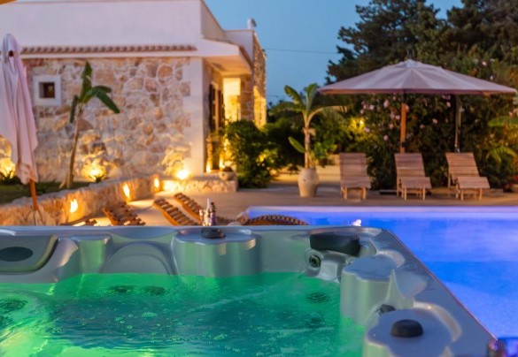 Jacuzzi e area piscina esterna illuminata di sera – Villa I Mori