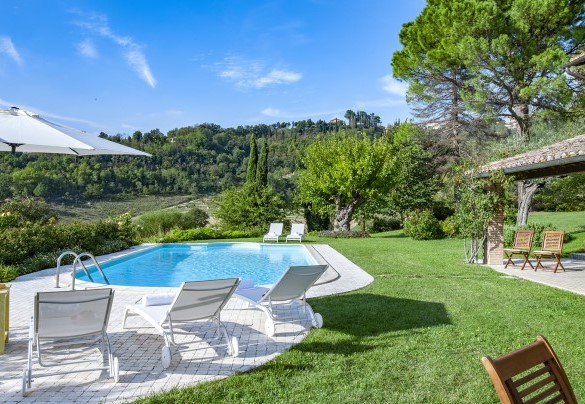 The swimming pool with marble pebbled solarium and lawn, sunbeds and umbrella - Villa Il Baiocco