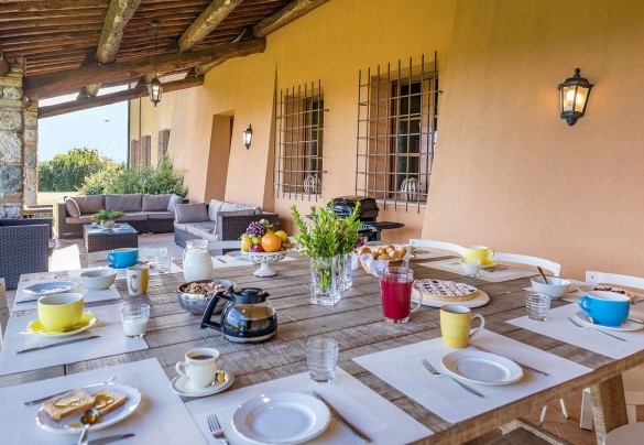 Nel portico davanti alla casa sono allestiti la zona pranzo e il salotto – Villa Il Foramasso 