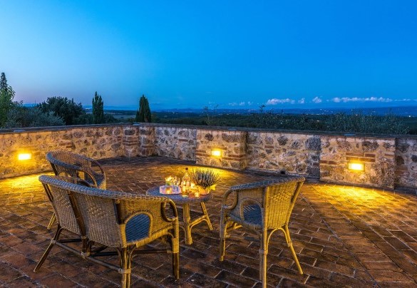 I profili illuminati dei borghi circostanti definiscono lo skyline notturno visto dalla terrazza – Villa Il Foramasso