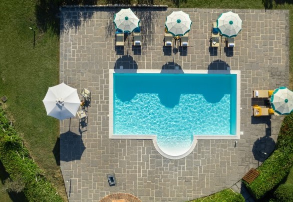 La piscina, dotata di un ampio solarium in pietra, vista dall'alto - Villa il Magnifico 