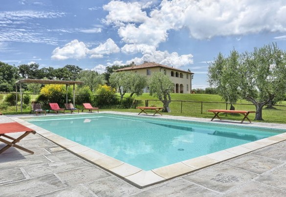 The pool is surrounded by a stone floor - Villa Il Meluccio