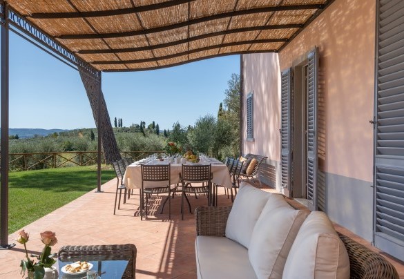 L’ampio pergolato lastricato, arredato con tavolo da pranzo e zona salotto – Villa Il Pino