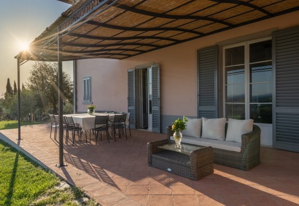 All’uscita della sala da pranzo e del salotto, si trovano un ampio pergolato lastricato, arredato con tavolo da pranzo e zona salotto – Villa Il Pino