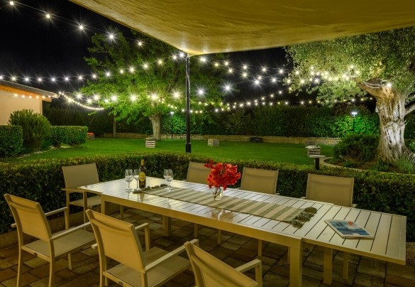 Evening aperitif in the garden among illuminated olive trees - Villa Isola