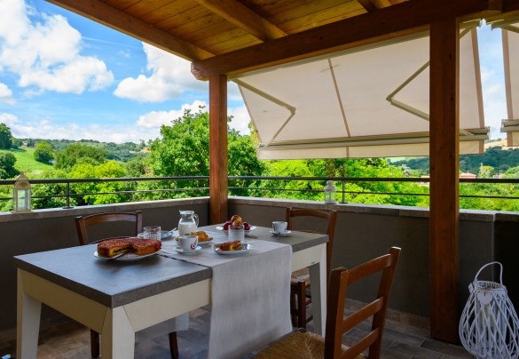 Covered terrace with breakfast table and scenic views - Villa Isola