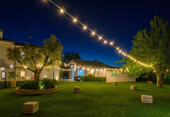 Garden illuminated by string lights in the evening - Villa Isola