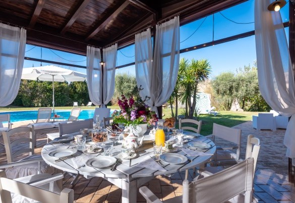 Veranda set up as a dining area with kitchen, overlooking the swimming pool – Villa Isotta	