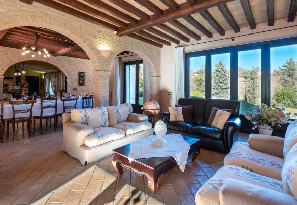 The welcoming living area divided by columns and consisting of the sitting area with TV on one side and the dining area on the other – Villa Isotta