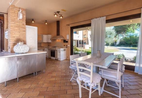 Veranda set up as a dining area with kitchen, overlooking the swimming pool – Villa Isotta	