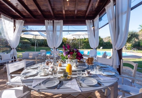 Veranda set up as a dining area with kitchen, overlooking the swimming pool – Villa Isotta