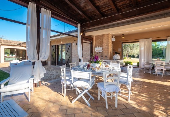 Veranda set up as a dining area with kitchen, overlooking the swimming pool – Villa Isotta	