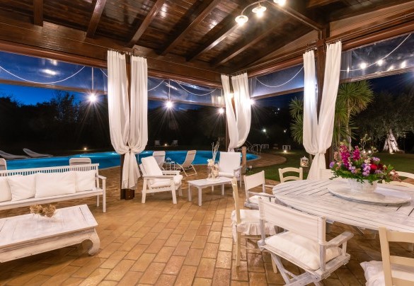 Veranda set up as a dining area with kitchen, overlooking the swimming pool – Villa Isotta	
