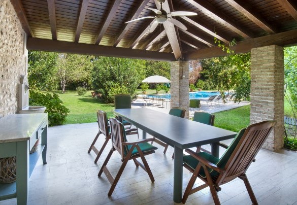 La veranda vicino alla piscina ospita un generoso tavolo con sedie ed è corredata di BBQ - Villa l'Oleandra